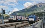 Gleich zwei Werbeloks in Brig: Die Re 460 041-7  Rotes Kreuz  mit ihrem IC nach Romanshorn und die Re 460 079-7  Gotthardo 2016  mit ihrem IR nach Genève Aéroport.