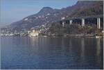 Ein Blick über den See bei Villeneuve zum Château de Chillon und etwas versteckt erkennt man einen SBB RABe 512 auf seiner Fahrt in Richtung Lausanne.