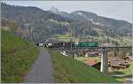 Kurz nach Gstaad fährt die MOB Ge 4/4 8004  Swisstainable  mit ihrem GoldenPass Express auf der Fahrt von Interlaken nach Montreux über den Grubenbach Viadukt.