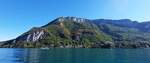 Rundfahrt mit dem Boot über den Lac d’Annecy, Blick über den See auf die Felsen und die Herbstlichen Farben des Waldes nahe Chavoire.